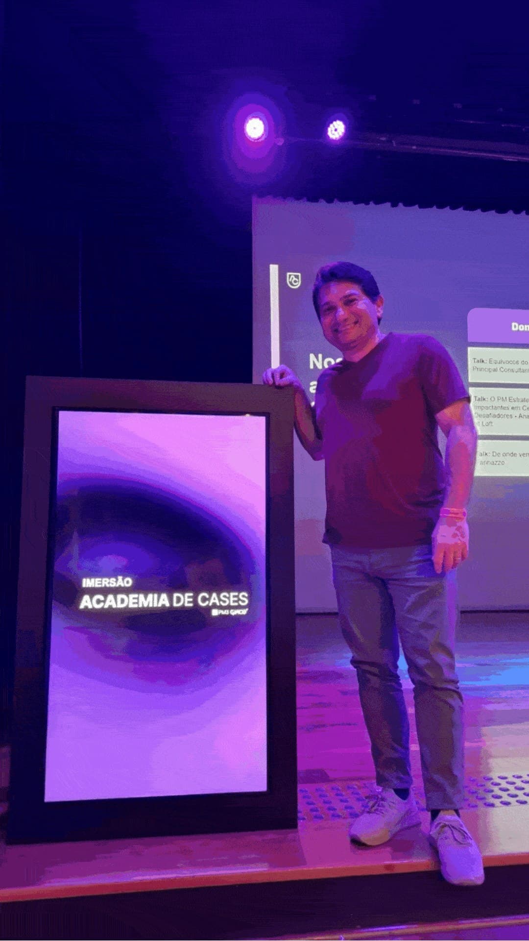 Gustavo Mistrinelli ao lado do painel Imersão Academia de Cases, no palco da PM3